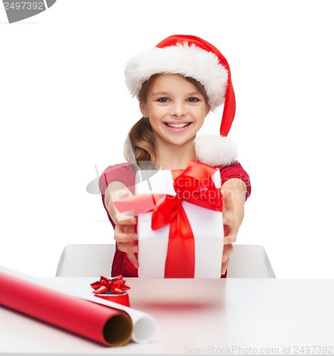 Image of smiling girl in santa helper hat with gift box