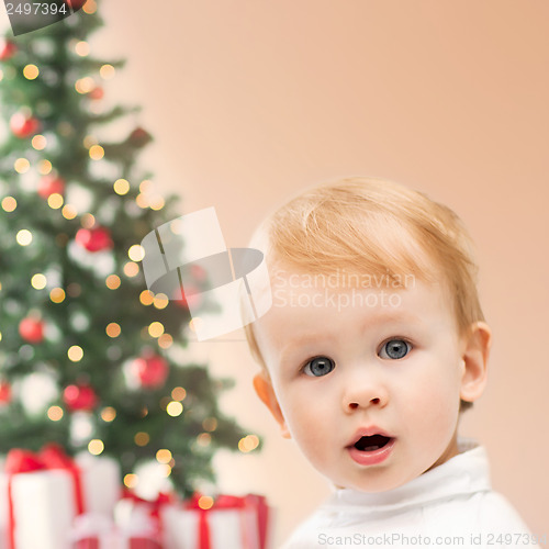 Image of happy little boy with christmas tree and gifts