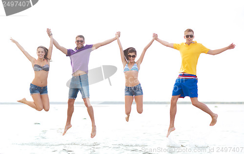 Image of group of friends or couples jumping on the beach