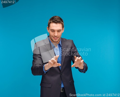 Image of businessman working with imaginary virtual screen