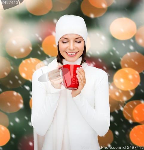 Image of woman in hat with red tea or coffee mug