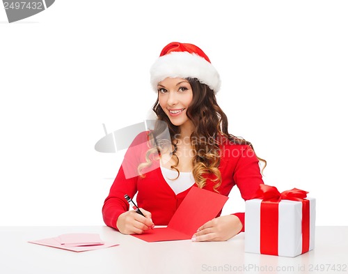 Image of smiling woman in santa helper hat with postcard