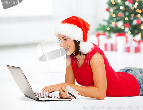 Image of woman in santa hat with laptop and credit card