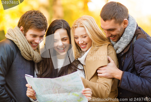 Image of couples with tourist map in autumn park