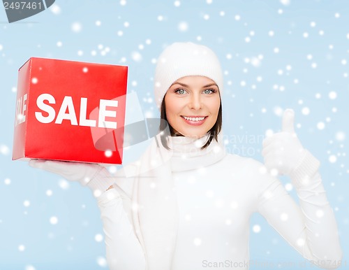 Image of woman in winter clothes with red sale sign