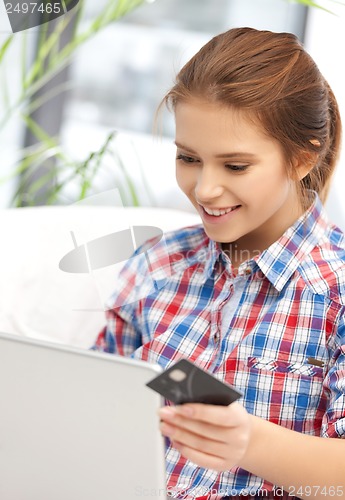 Image of happy teenage girl with laptop and credit card