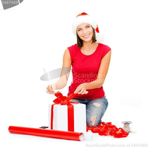 Image of smiling woman in santa helper hat with gift box