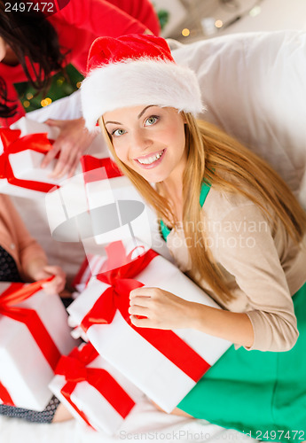 Image of woman in santa helper hat with many gift boxes
