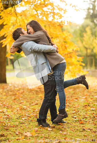 Image of romantic couple playing in the autumn park