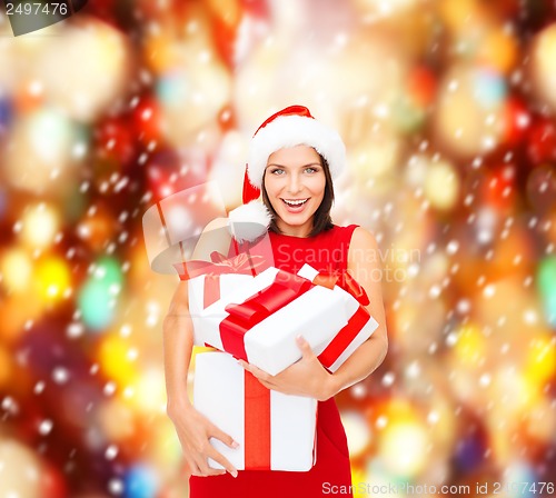 Image of woman in santa helper hat with many gift boxes