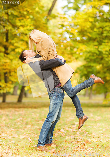 Image of romantic couple playing in the autumn park