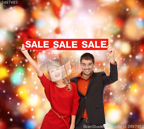 Image of woman and man with red sale sign