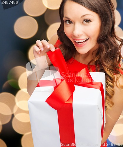 Image of smiling woman in red dress with gift box