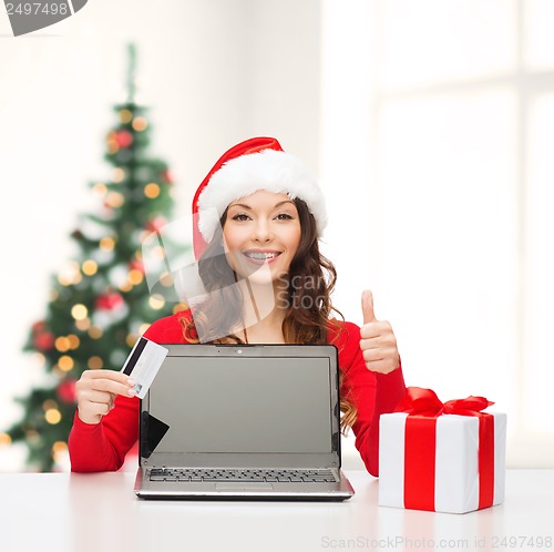 Image of woman with gift, laptop computer and credit card