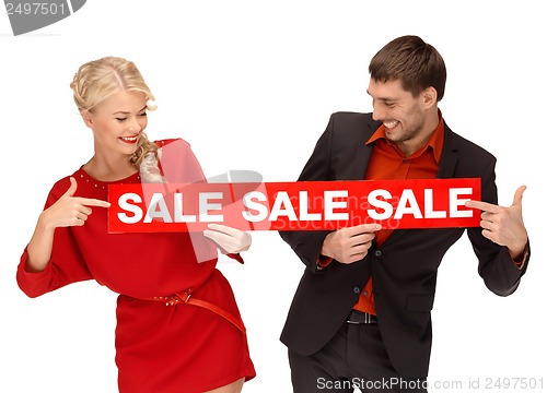 Image of woman and man with red sale sign