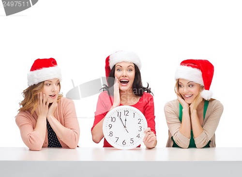 Image of women in santa helper hats with clock showing 12