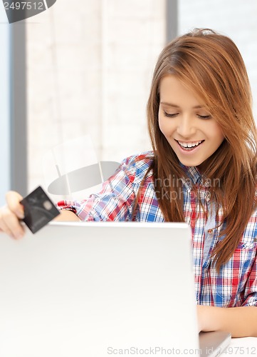 Image of happy teenage girl with laptop and credit card