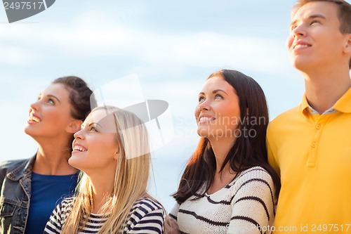 Image of group of friends looking up on the beach
