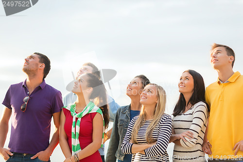 Image of group of friends looking up on the beach