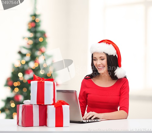 Image of woman with gift boxes and laptop computer