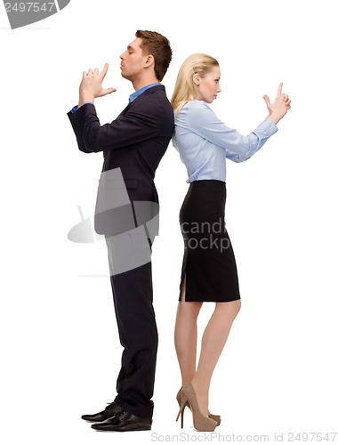 Image of businesswoman and businessman with imaginary guns