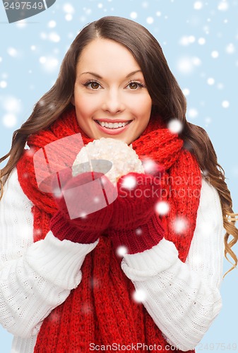 Image of woman in scarf and mittens with christmas ball