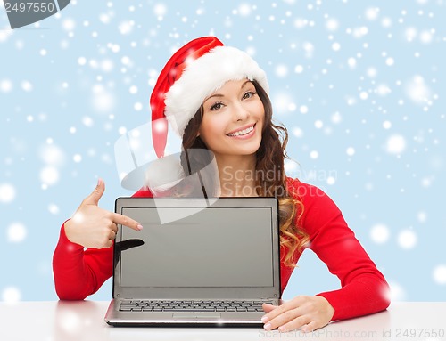 Image of woman in santa helper hat with laptop computer