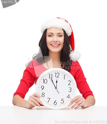 Image of woman in santa helper hat with clock showing 12