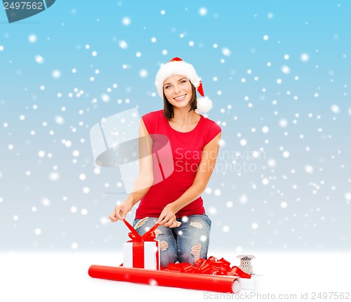 Image of smiling woman in santa helper hat with gift box