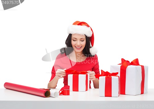 Image of woman in santa helper hat with many gift boxes