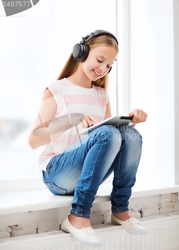 Image of girl with tablet pc and headphones at home