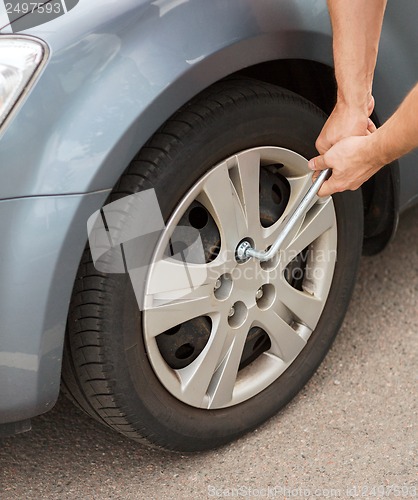 Image of man changing tire