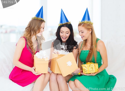 Image of three smiling women in blue hats with gift boxes