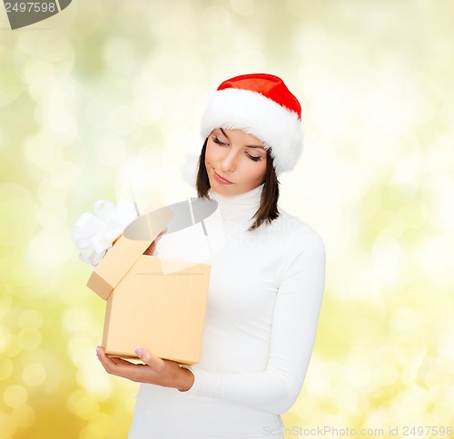 Image of suspicious woman in santa helper hat with gift box