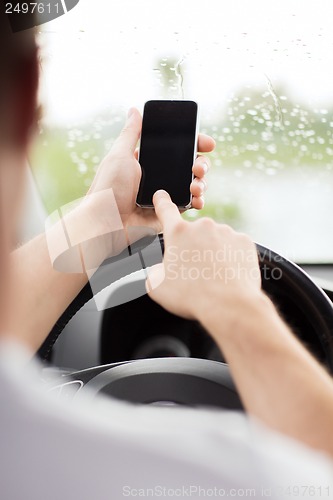 Image of man using phone while driving the car