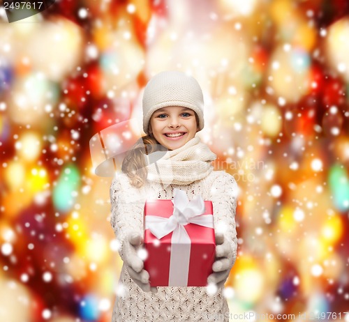 Image of girl in hat, muffler and gloves with gift box