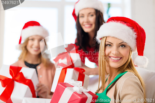 Image of women in santa helper hats with many gift boxes