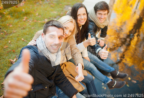 Image of group of friends having fun in autumn park