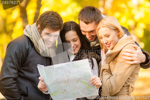 Image of couples with tourist map in autumn park