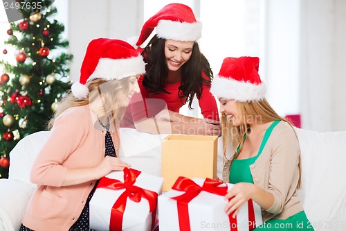 Image of women in santa helper hats with many gift boxes