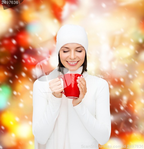 Image of woman in hat with red tea or coffee mug