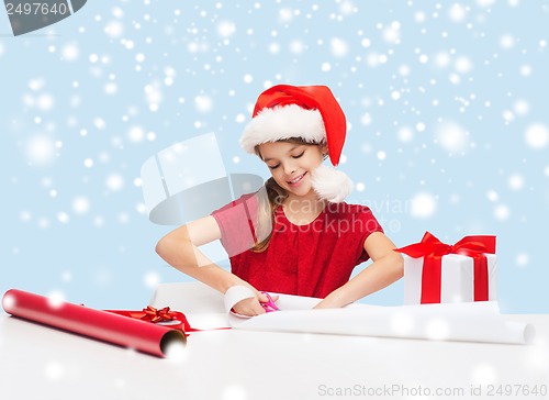 Image of smiling girl in santa helper hat with gift box