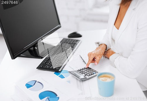 Image of woman hand with calculator and papers