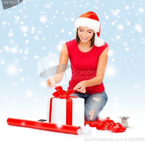 Image of smiling woman in santa helper hat with gift box