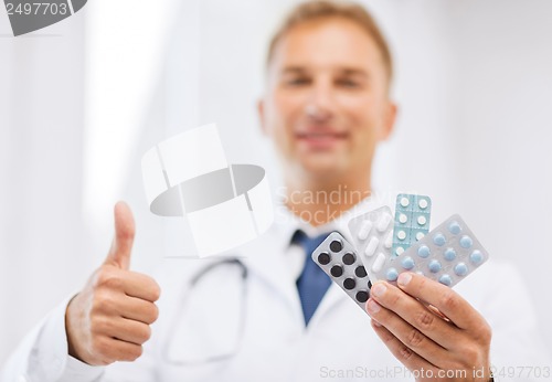 Image of male doctor with packs of pills