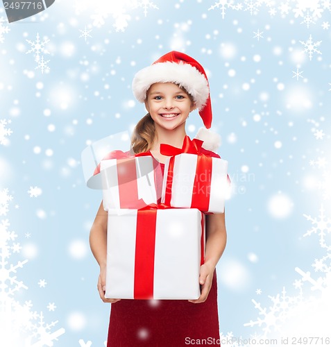 Image of girl in santa helper hat with many gift boxes