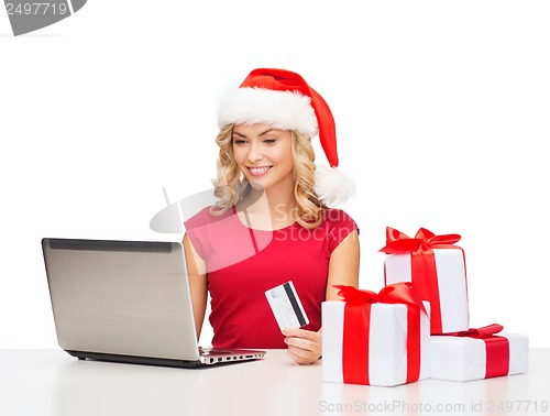 Image of woman with gifts, laptop computer and credit card