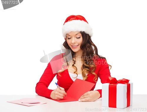 Image of smiling woman in santa helper hat with postcard