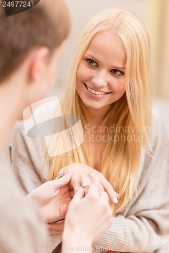 Image of romantic man proposing to beautiful woman