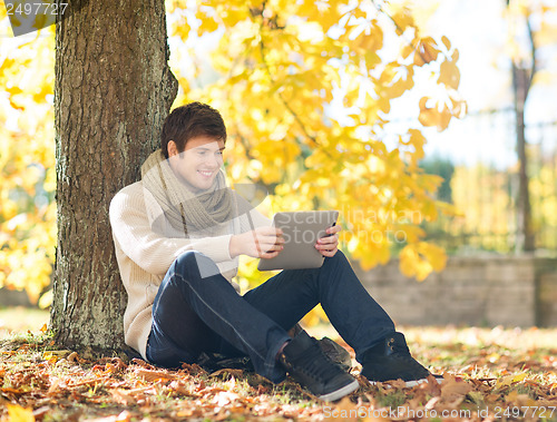 Image of man with tablet pc in autumn park